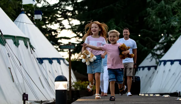 Children running along glamping runway