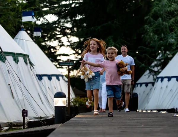 Children running along glamping runway